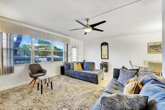 living room with ceiling fan and a textured ceiling