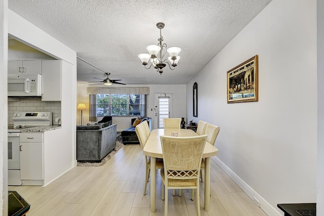 dining room featuring a textured ceiling, ceiling fan with notable chandelier, and light hardwood / wood-style floors