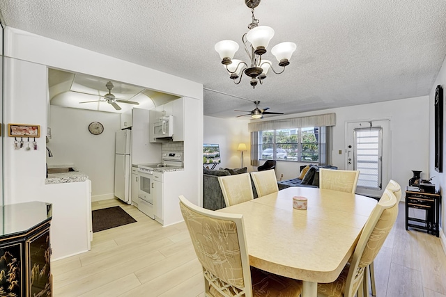 dining space with a textured ceiling, ceiling fan with notable chandelier, light hardwood / wood-style flooring, and sink