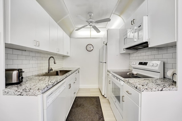 kitchen with ceiling fan, white appliances, light stone countertops, white cabinets, and sink