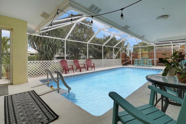 view of pool with a patio and glass enclosure