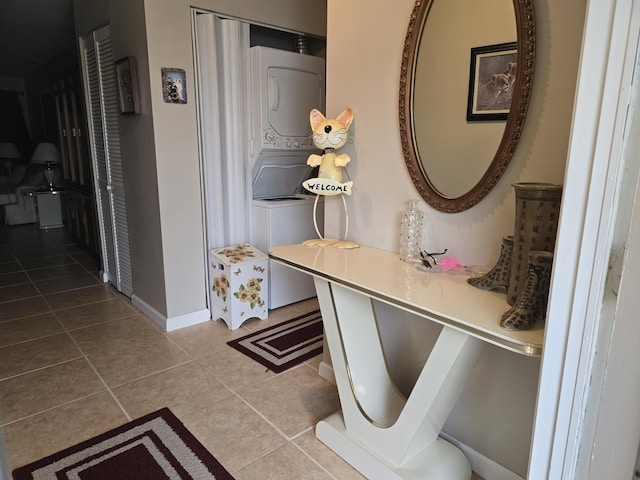 hallway featuring light tile patterned floors and stacked washer and dryer