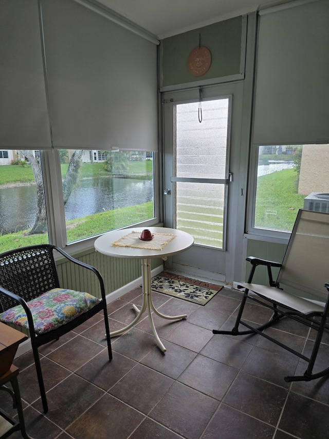 sunroom featuring a water view