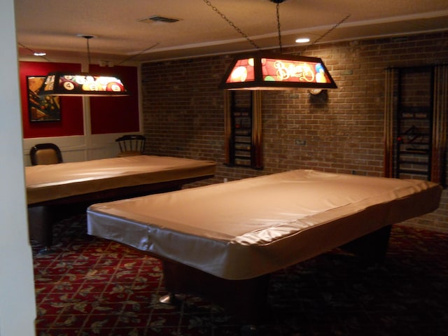 playroom featuring dark colored carpet, brick wall, and billiards