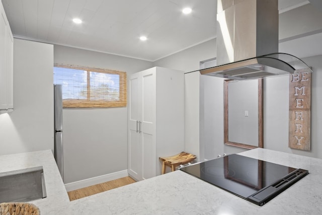 kitchen with light hardwood / wood-style flooring, black electric cooktop, and island range hood