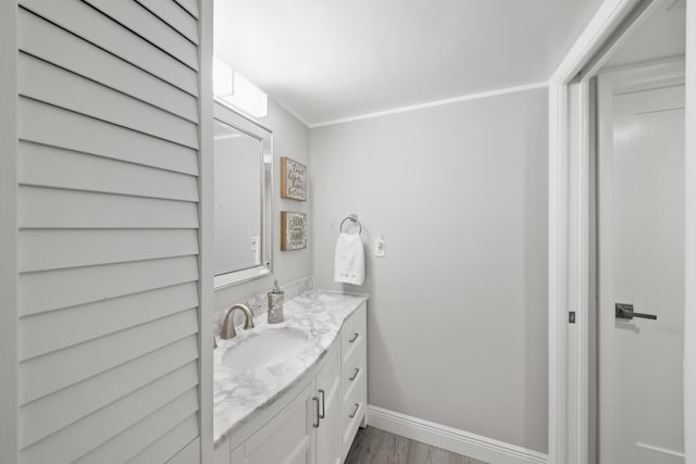 bathroom with wood-type flooring, vanity, and crown molding