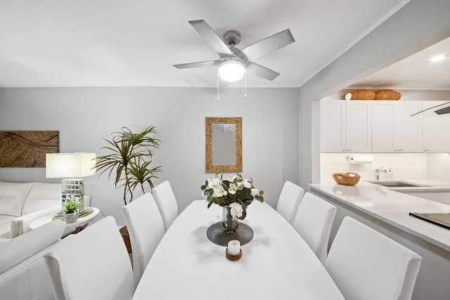 dining space featuring sink and ceiling fan