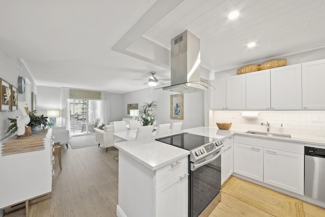 kitchen featuring sink, white cabinetry, island exhaust hood, and appliances with stainless steel finishes