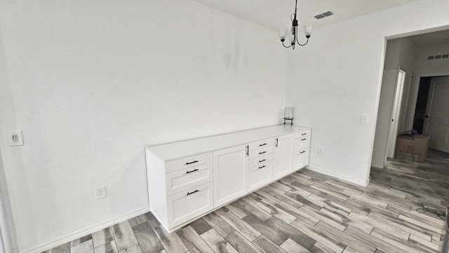 interior details featuring a chandelier and hardwood / wood-style floors