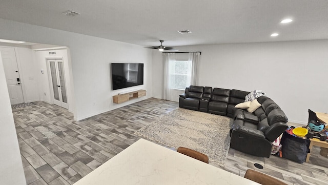 living room with ceiling fan and dark wood-type flooring