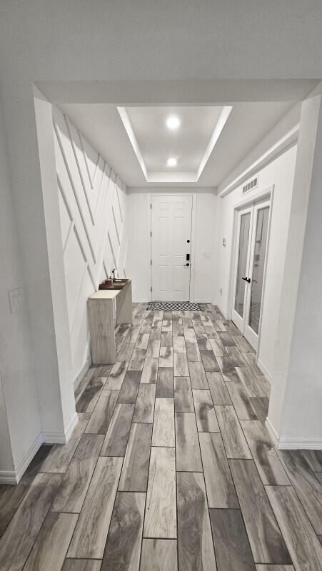 interior space with french doors and a tray ceiling