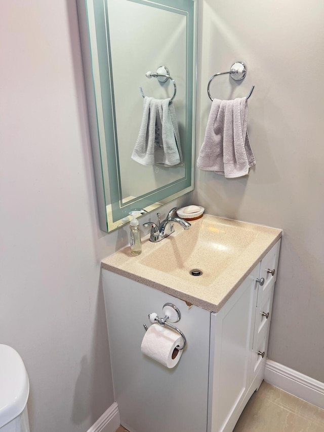 bathroom with toilet, tile patterned flooring, and vanity