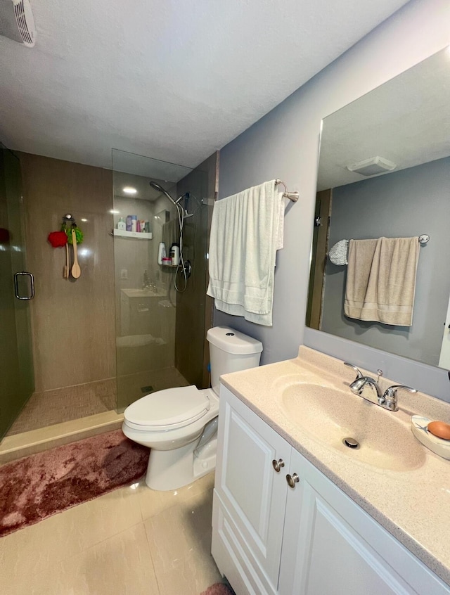 bathroom featuring toilet, tile patterned flooring, a shower with shower door, and vanity