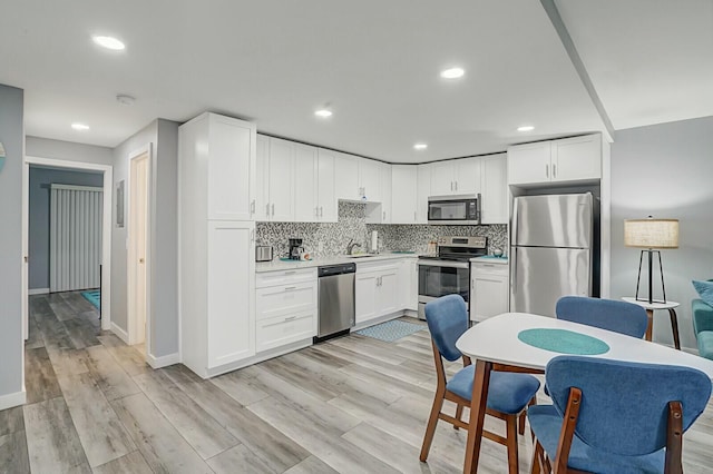 kitchen with white cabinetry, appliances with stainless steel finishes, and decorative backsplash