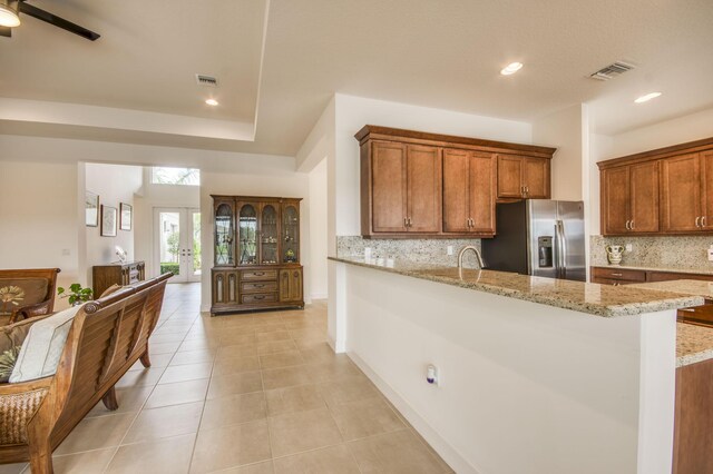 dining area with a water view, light tile patterned flooring, and a chandelier