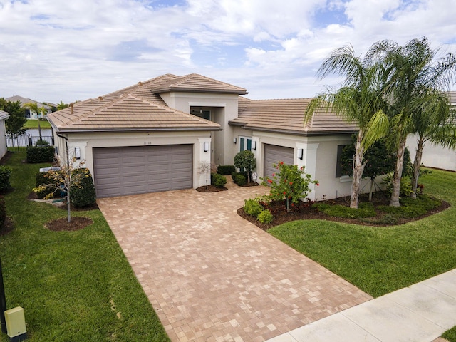 view of front facade featuring a front lawn, decorative driveway, an attached garage, and stucco siding