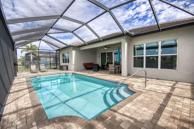 view of swimming pool with a patio area, a lanai, and ceiling fan