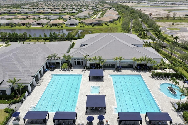 view of swimming pool with area for grilling and a water view