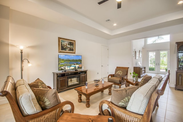 tiled living room with ceiling fan and french doors