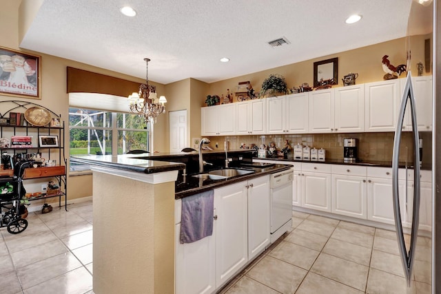 kitchen with white cabinetry, white dishwasher, sink, and a center island with sink