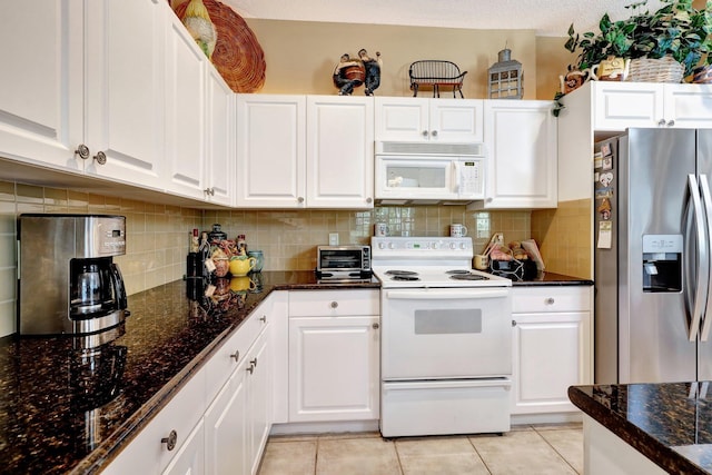 kitchen with white appliances, decorative backsplash, white cabinets, and light tile patterned flooring