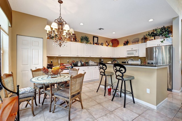 kitchen featuring white cabinetry, light tile patterned floors, tasteful backsplash, and stainless steel refrigerator with ice dispenser