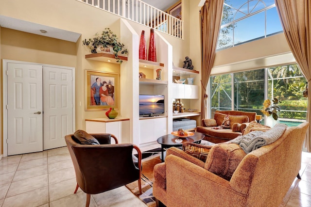 living room with a high ceiling, light tile patterned flooring, and built in shelves