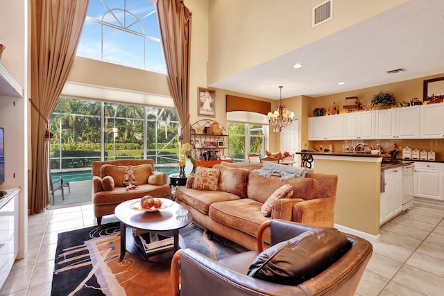 living room with a high ceiling, light tile patterned floors, and a chandelier