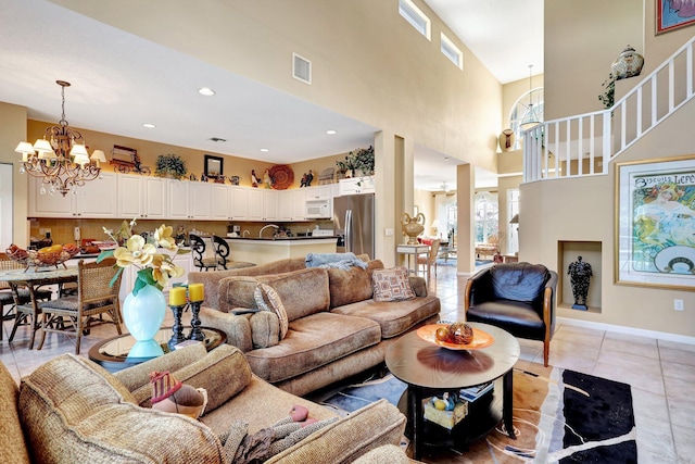 living room featuring light tile patterned flooring, a chandelier, and a high ceiling