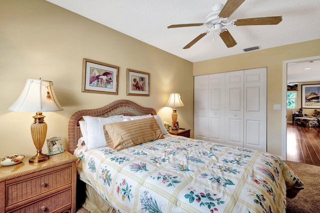 bedroom with hardwood / wood-style flooring, ceiling fan, a closet, and a textured ceiling