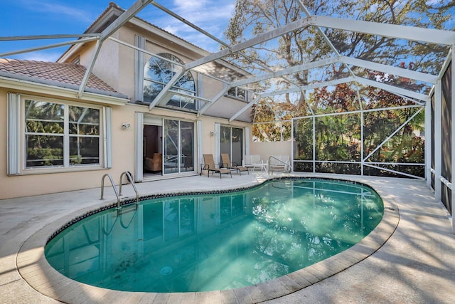 view of pool with a patio area and glass enclosure