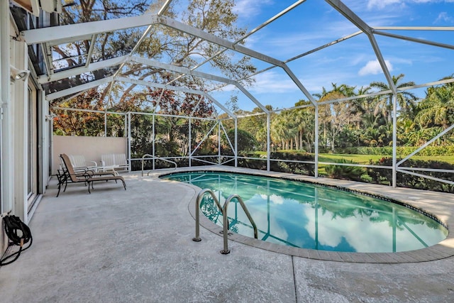 view of swimming pool featuring glass enclosure and a patio area