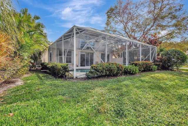 rear view of property with a yard and a lanai