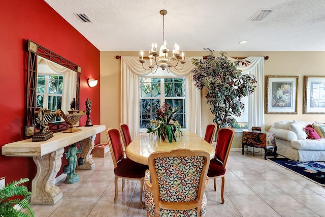 tiled dining room featuring a chandelier and a textured ceiling