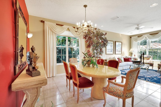 dining area with light tile patterned floors, ceiling fan with notable chandelier, and a textured ceiling