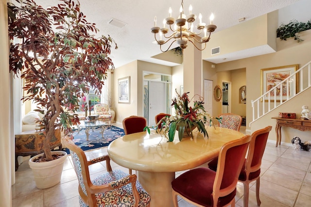 dining room featuring an inviting chandelier, a textured ceiling, and light tile patterned floors