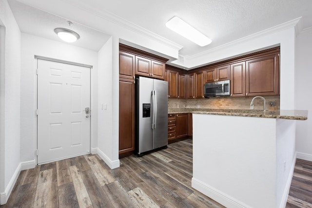 kitchen featuring appliances with stainless steel finishes, dark wood-type flooring, decorative backsplash, light stone counters, and crown molding