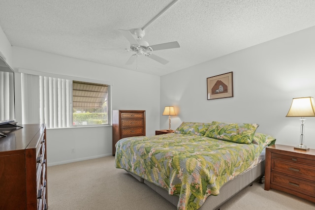 bedroom featuring a textured ceiling, light colored carpet, and ceiling fan