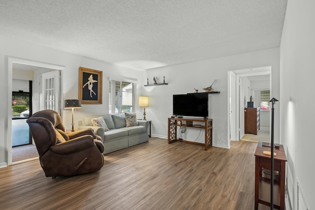 living room featuring dark wood-type flooring and a textured ceiling