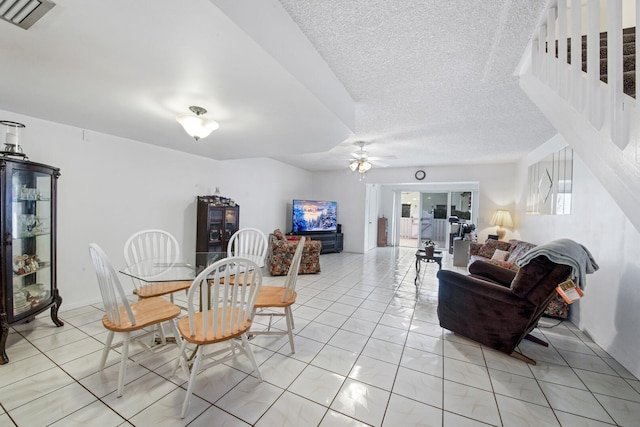 living room with ceiling fan and a textured ceiling