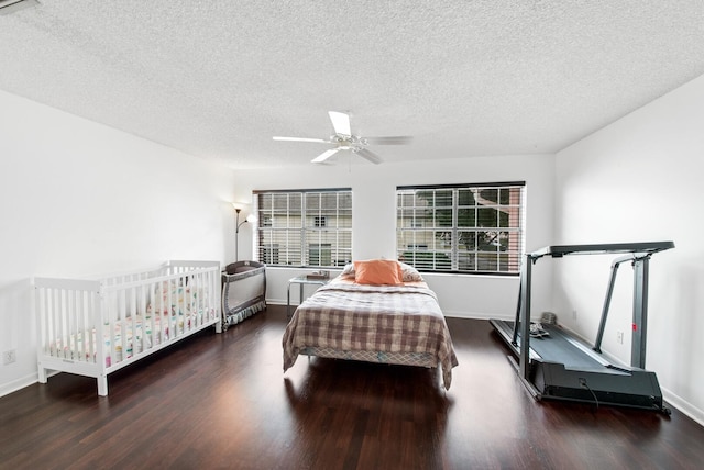 bedroom with ceiling fan, dark hardwood / wood-style floors, and a textured ceiling