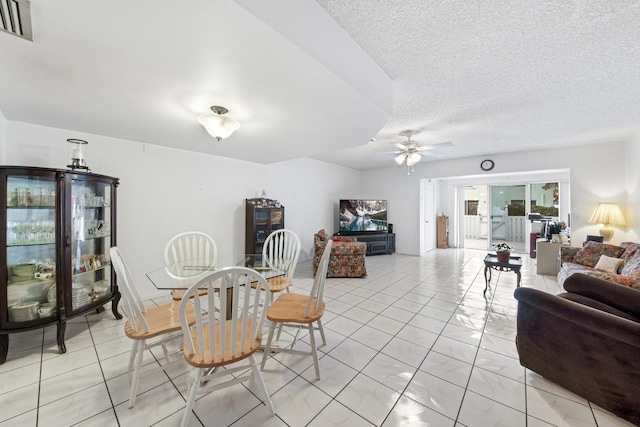 dining space featuring ceiling fan and a textured ceiling