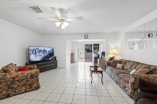 living room featuring ceiling fan, a textured ceiling, and light tile patterned flooring