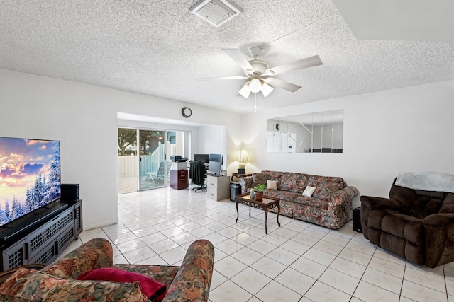 living room featuring ceiling fan, light tile patterned floors, and a textured ceiling