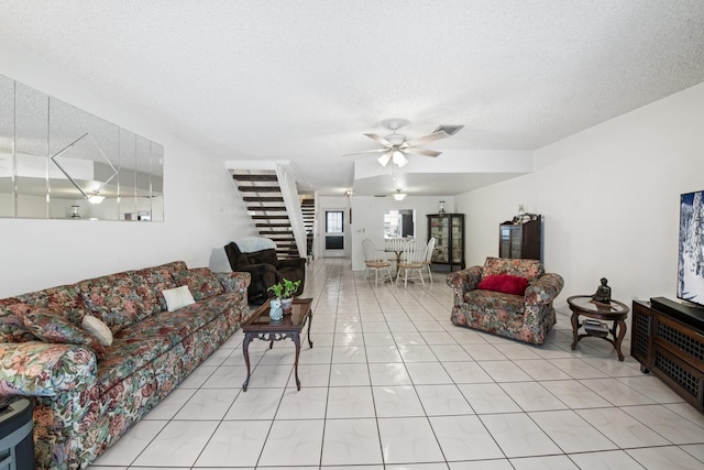 tiled living room with ceiling fan and a textured ceiling