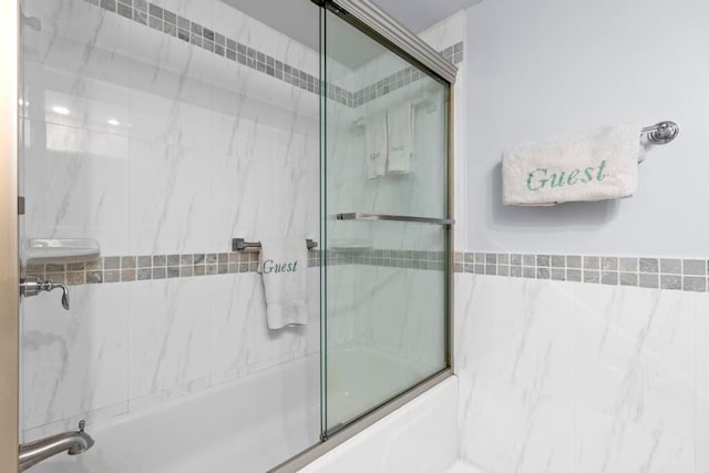 bathroom featuring bath / shower combo with glass door