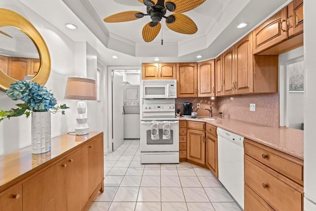 kitchen with light tile patterned floors, ceiling fan, decorative backsplash, a tray ceiling, and white appliances