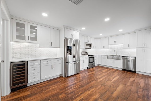 kitchen featuring dark hardwood / wood-style floors, sink, white cabinets, beverage cooler, and stainless steel appliances