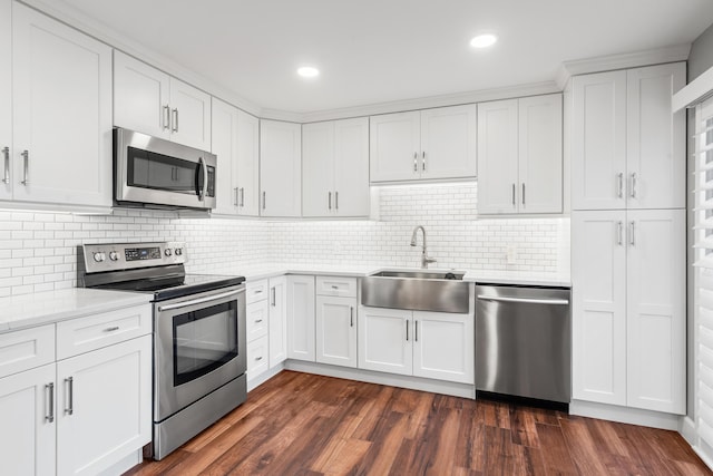 kitchen with sink, tasteful backsplash, dark hardwood / wood-style flooring, stainless steel appliances, and white cabinets