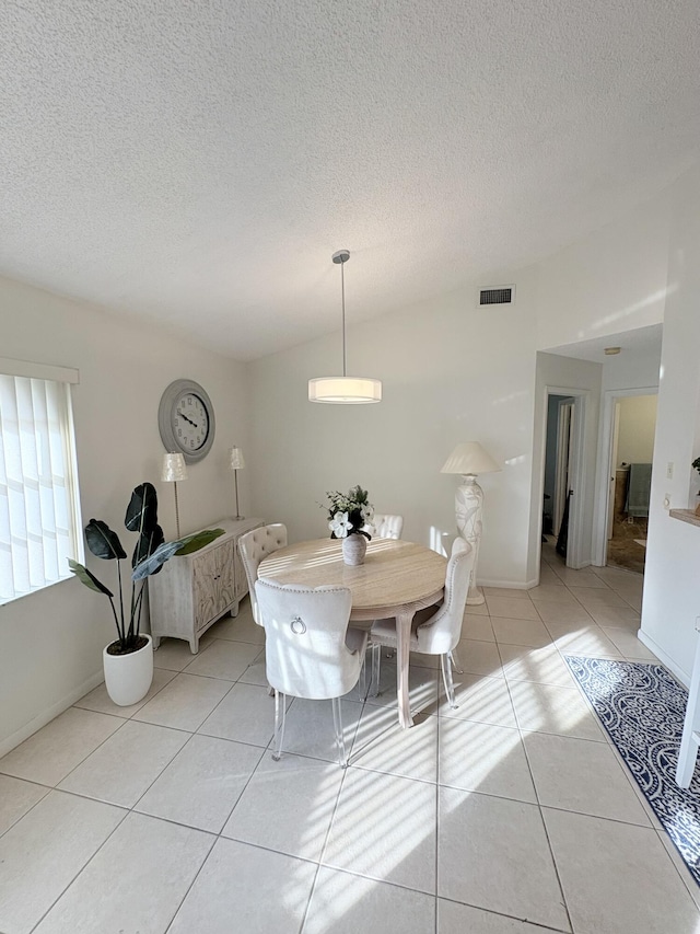 tiled dining space featuring a textured ceiling